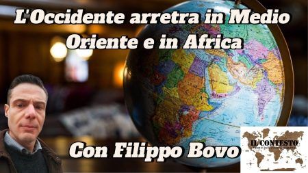 Un uomo posa accanto a un mappamondo con riferimenti al ritiro di Occidente in Medio Oriente e in Africa.