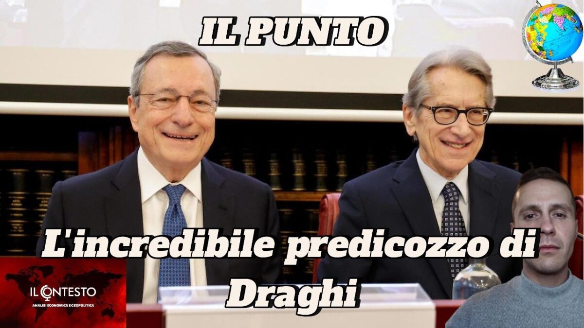 Due uomini in giacca e cravatta, tra cui Draghi, siedono sorridenti a una scrivania con un piccolo mappamondo in alto a destra.