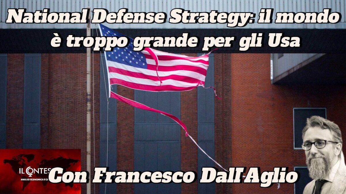 Una bandiera americana strappata è appesa fuori da un edificio, con la foto di un uomo barbuto e la scritta 