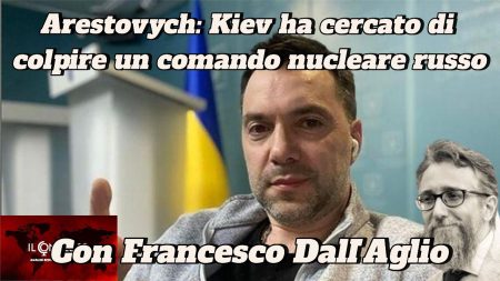 Un uomo alza il pollice davanti a una bandiera ucraina, con un testo di notizie e la foto di un altro uomo su 