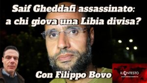 Saif Gheddafi assassinato: a chi giova una Libia divisa? Un uomo con gli occhiali è in piedi davanti a un fogliame; il testo italiano parla di Saif Gheddafi, della divisione della Libia e menziona il Somaliland.
