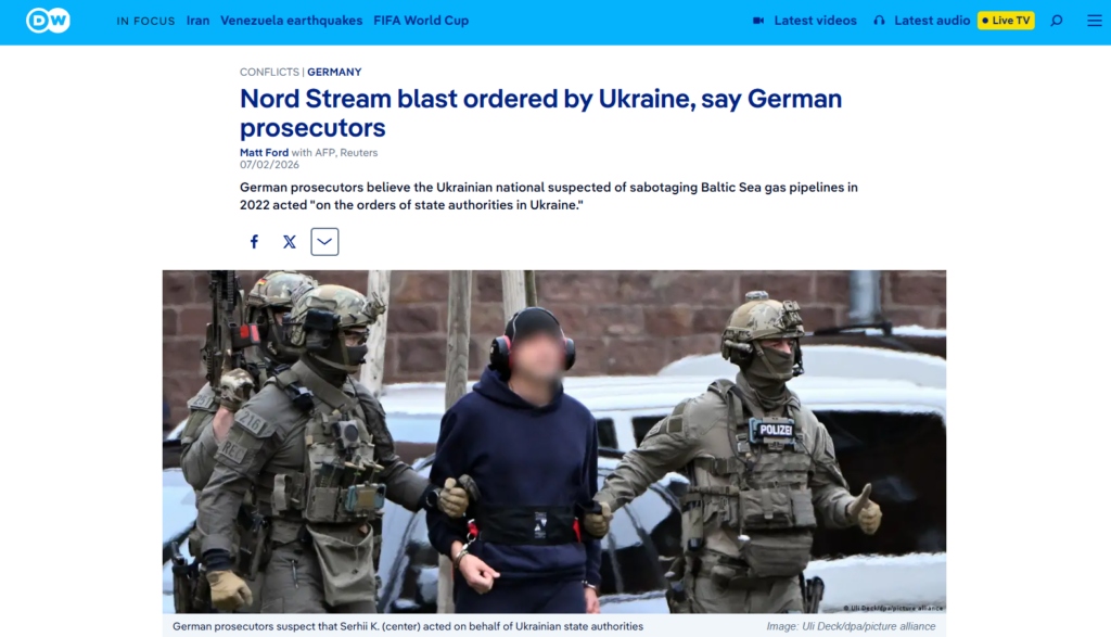 Agenti in divisa scortano una persona ammanettata, con il volto coperto da un cappuccio e vestita di scuro, nel corso di un'indagine sul sabotaggio del Nord Stream.